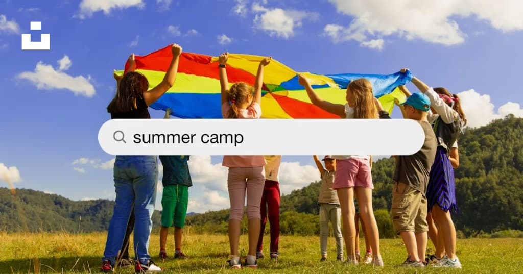 Children lifting a colorful parachute outdoors at HappyDale Summer Camp